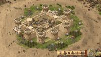 A big sandstone castle in Stronghold Crusader: Definitive Edition, surrounded by workers milling about.