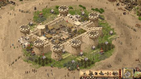 A big sandstone castle in Stronghold Crusader: Definitive Edition, surrounded by workers milling about.