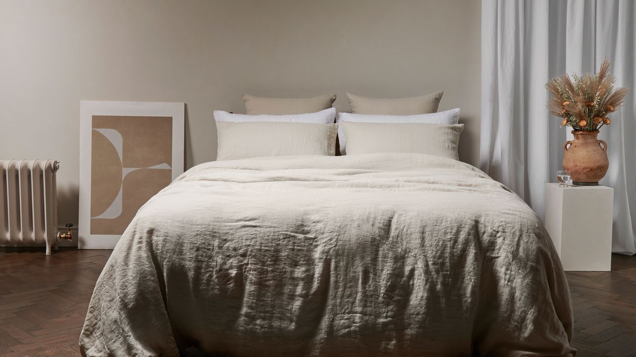 double bed made up with linen bedding in calm bedroom