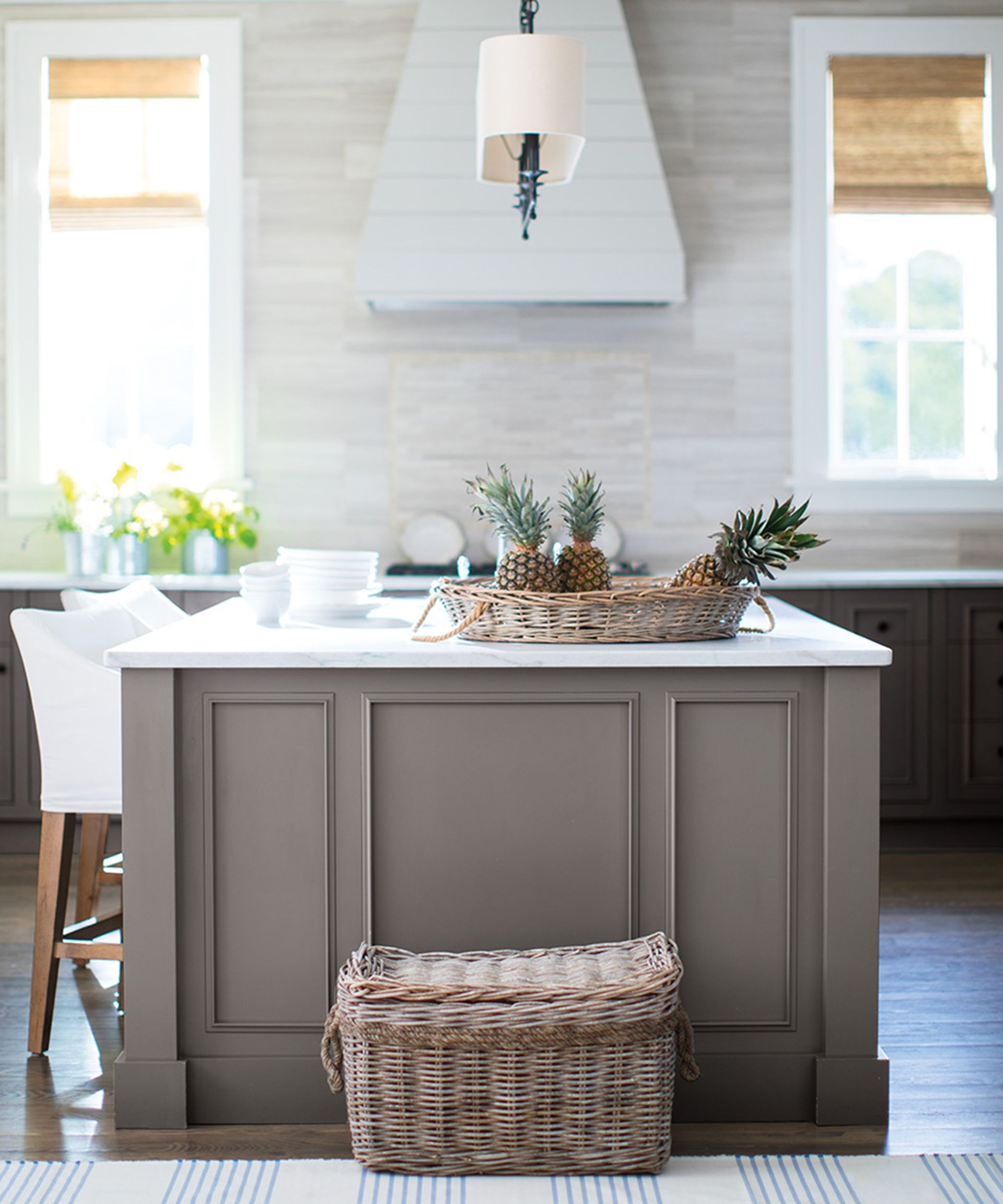 A small kitchen with island decorated with brown paint decor and lighting overhead