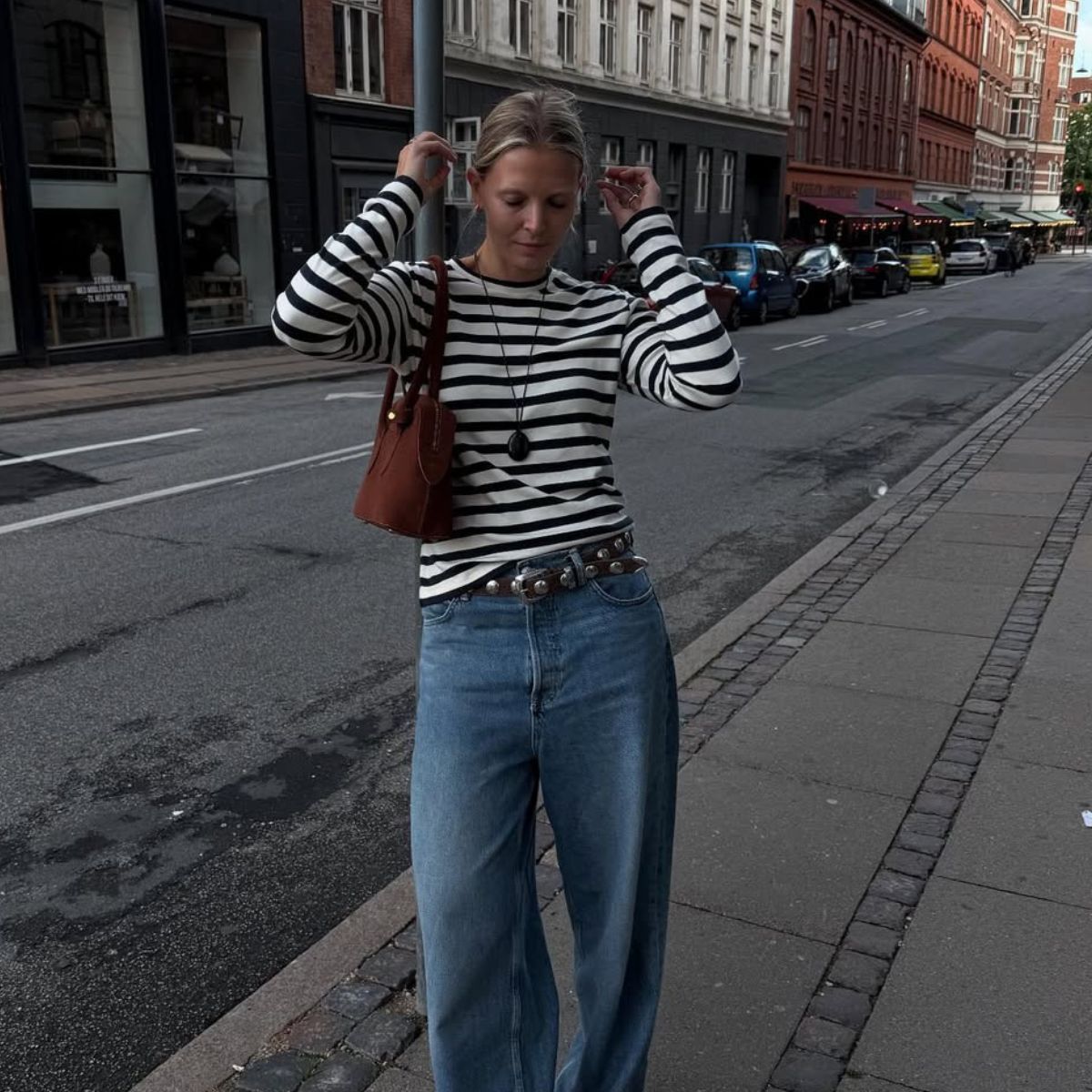 Hollie Mercedes wears a black and white long-sleeve striped tee with blue jeans