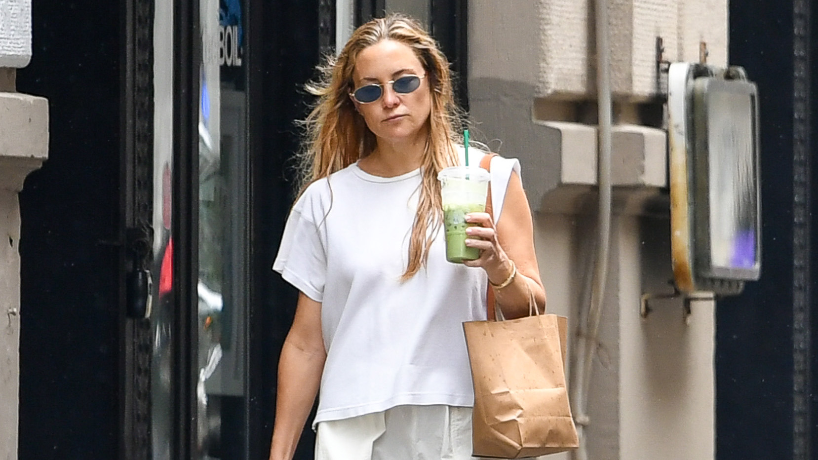 Kate Hudson wearing a white T-shirt, balloon cargo pants, and Birkenstock Boston clogs