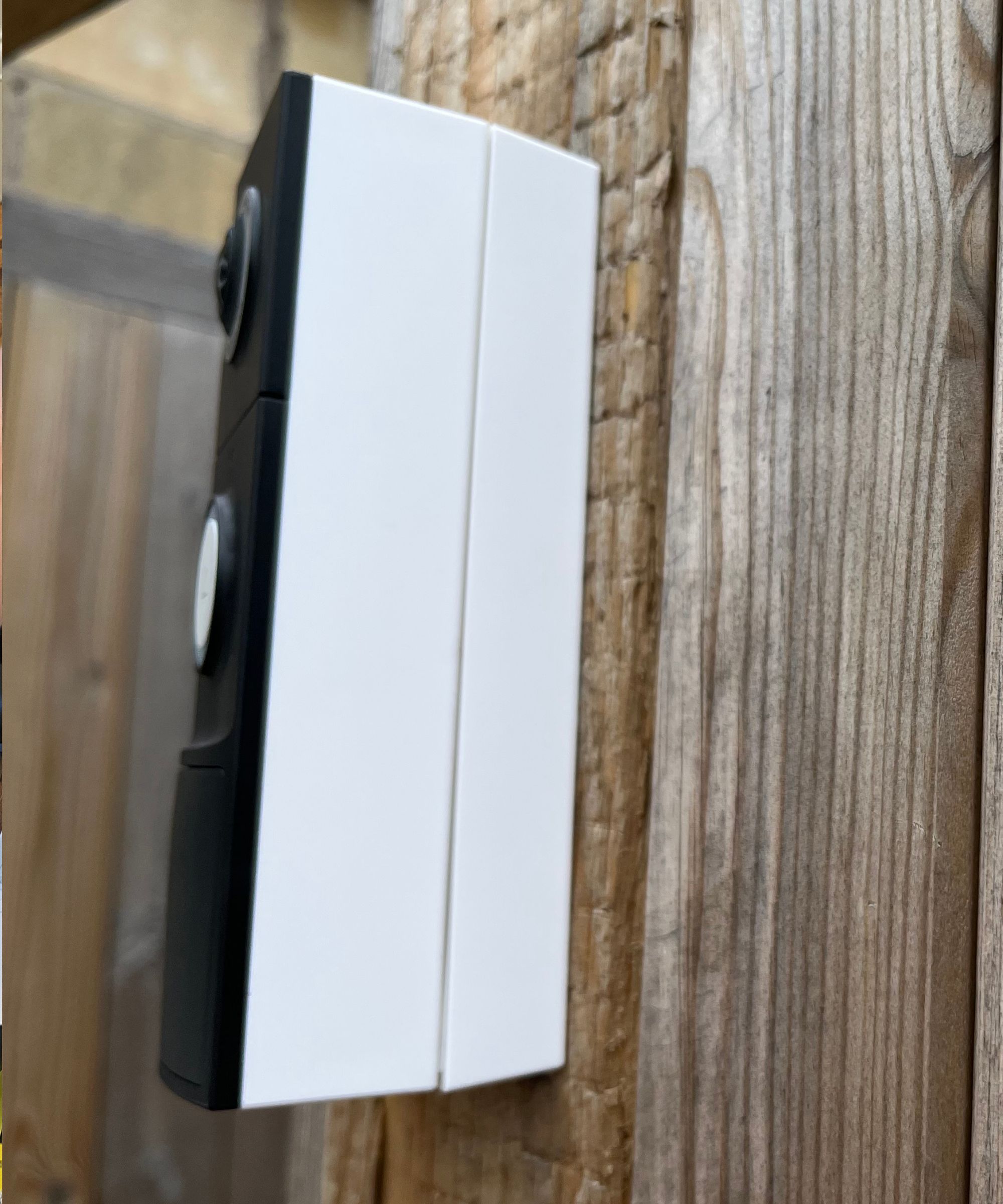 Looking at the side of the Tapo D235 which is installed on a wedge screwed to a wooden fence