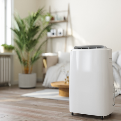 Close-up View Of Portable Air Conditioner With Blurred Living Room Background - stock photo