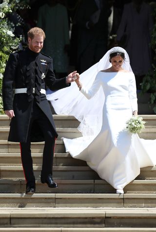 meghan markle and prince harry descend steps church after wedding wearing gown veil flowers