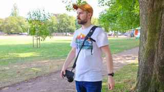 A man wearing the BlackRapid Sport Breathe Left and Right in a park