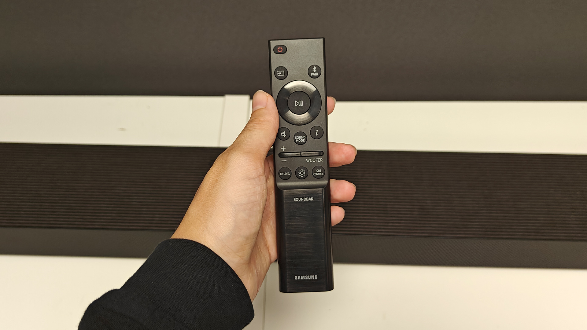 Samsung HW-QS90H Dolby Atmos soundbar remote held in hand