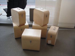 6 beige square wood cases displayed on a grey floor