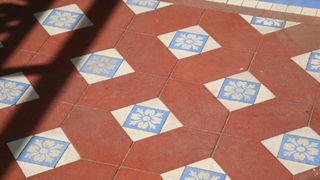 Original tiled floor, with orange tiles and decorative white and blue tiles in between
