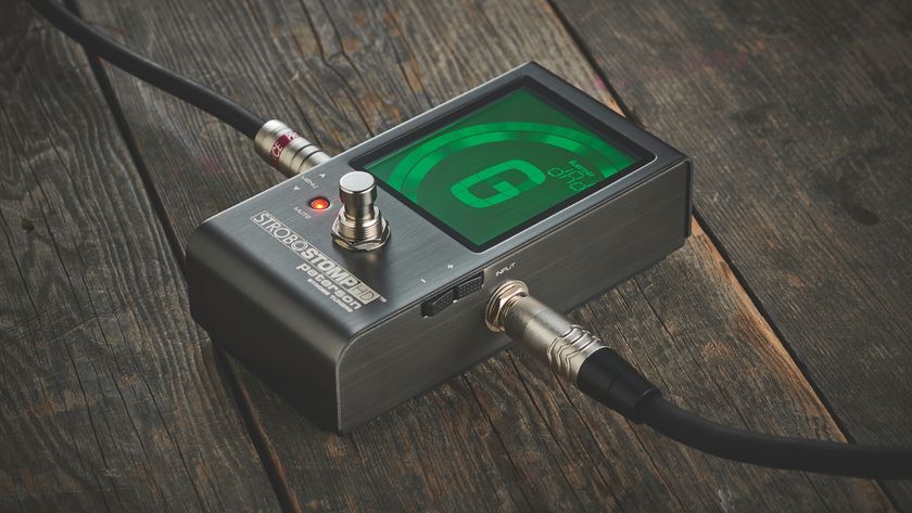 A Peterson StroboStomp guitar tuner lying on a wooden floor