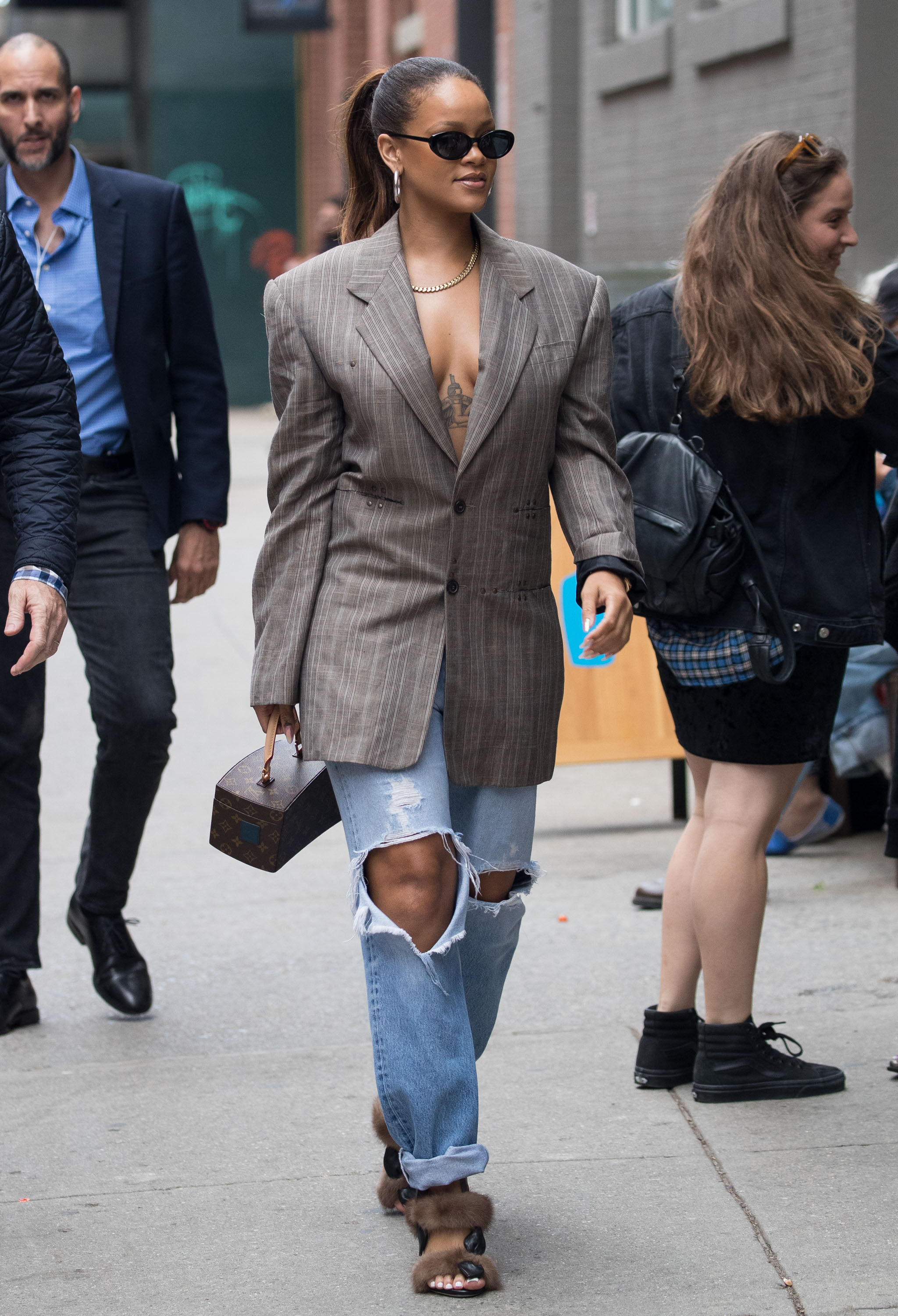 rihanna wearing a blazer, ripped jeans, and slides