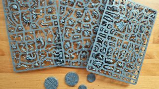 A selection of sprues and bases from Necromunda: Hive Secundus on a wooden table