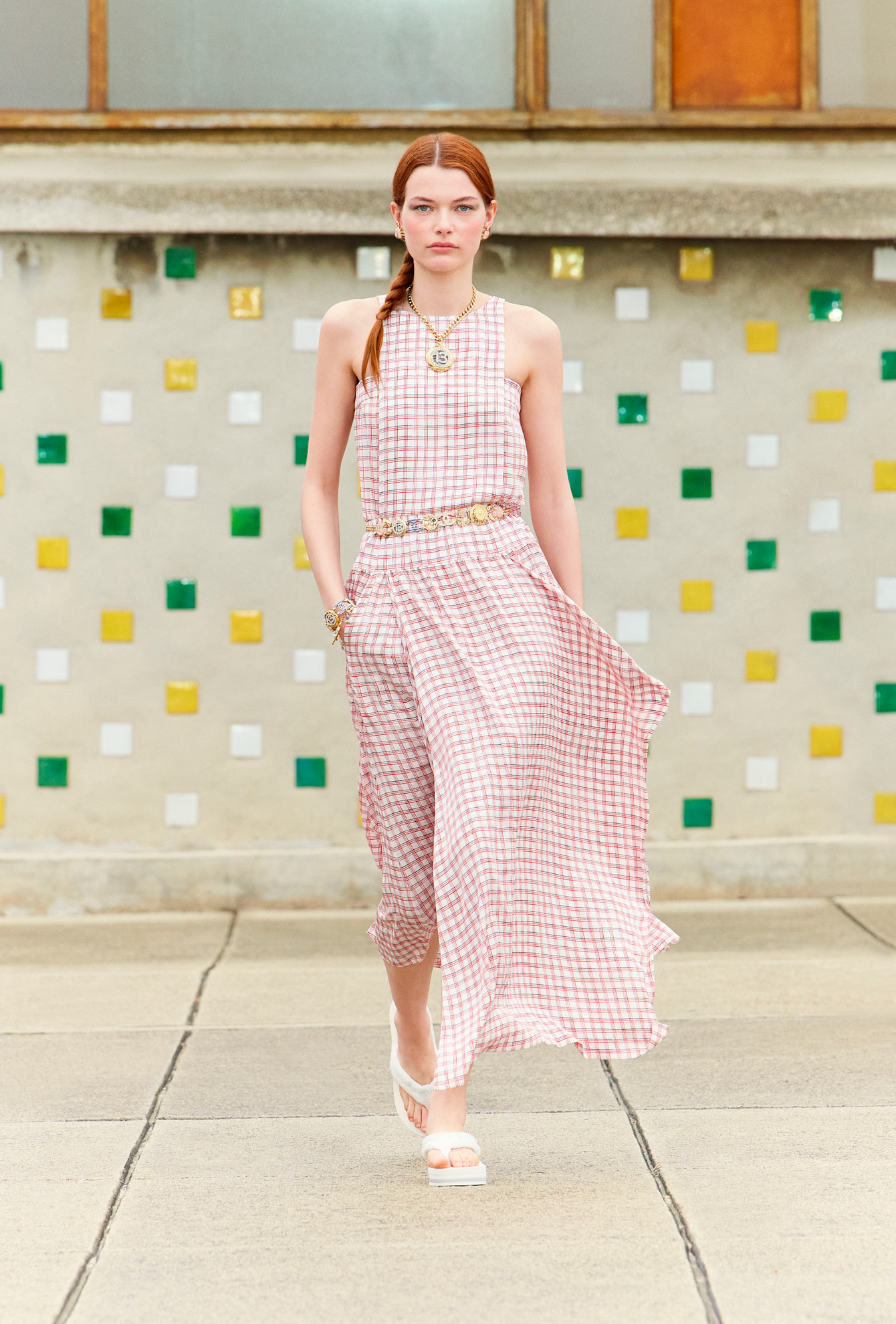 a model wearing a gingham dress from Chanel in front of a plain backdrop
