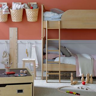 child's bedroom with peach wall and coral colour accessories