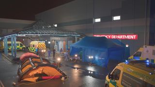 Embargo 08/08/23 Casualty set on night shoot, with contamination tents outside the ED.
