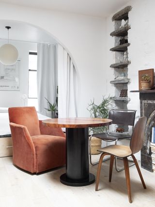A dining space with peach chair and black table