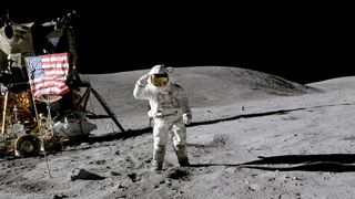 Front and center, astronaut Charles M. Duke, Jr., Apollo 16 lunar module pilot, salutes the U.S. flag.