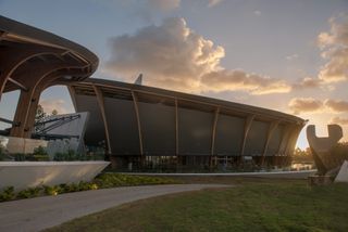 The exterior of the MACA building showing off its curved architecture and photographed at dusk