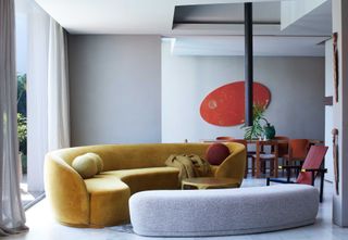 Mustard yellow sofa inside a grey-toned room