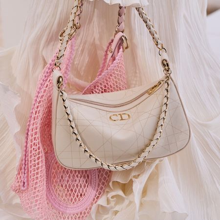 Model carries a Dior mini handbag and string shopping tote on the spring summer 2027 runway