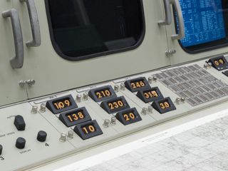 Close up view of the workstations at the recreated Johnson Space Centre in Houston featuring built-in screens along with multiple knobs, buttons and numbers