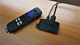 The Roku Express streaming device on a wooden surface