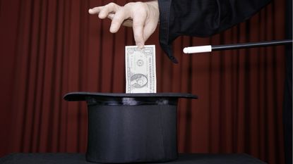 Against the backdrop of a red curtain, the hand of a magician pulls a dollar bill out of a top hat.
