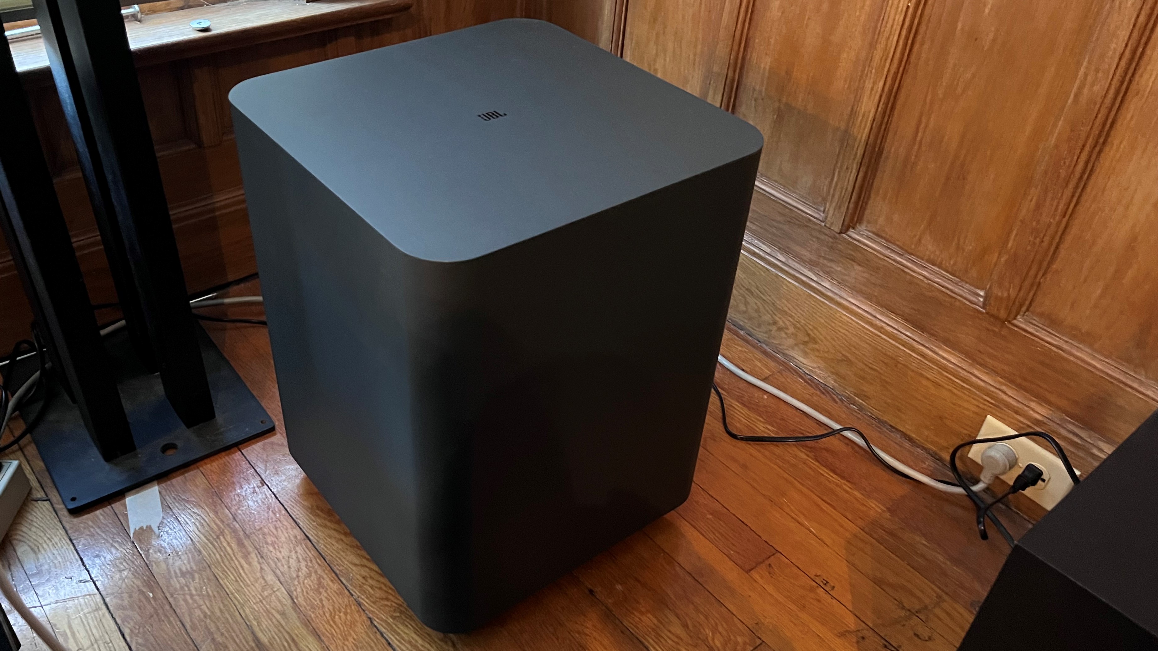 JBL Bar 1300X subwoofer in room with wood paneling