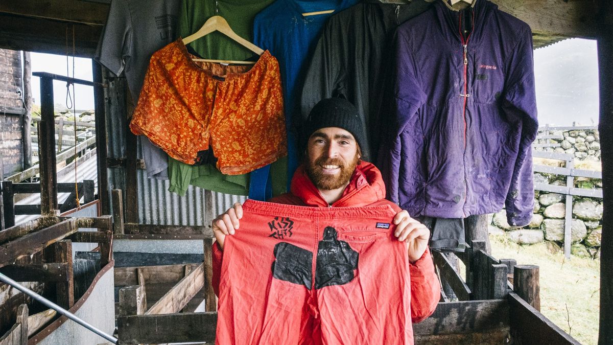 Man holding up repaired Patagonia pants