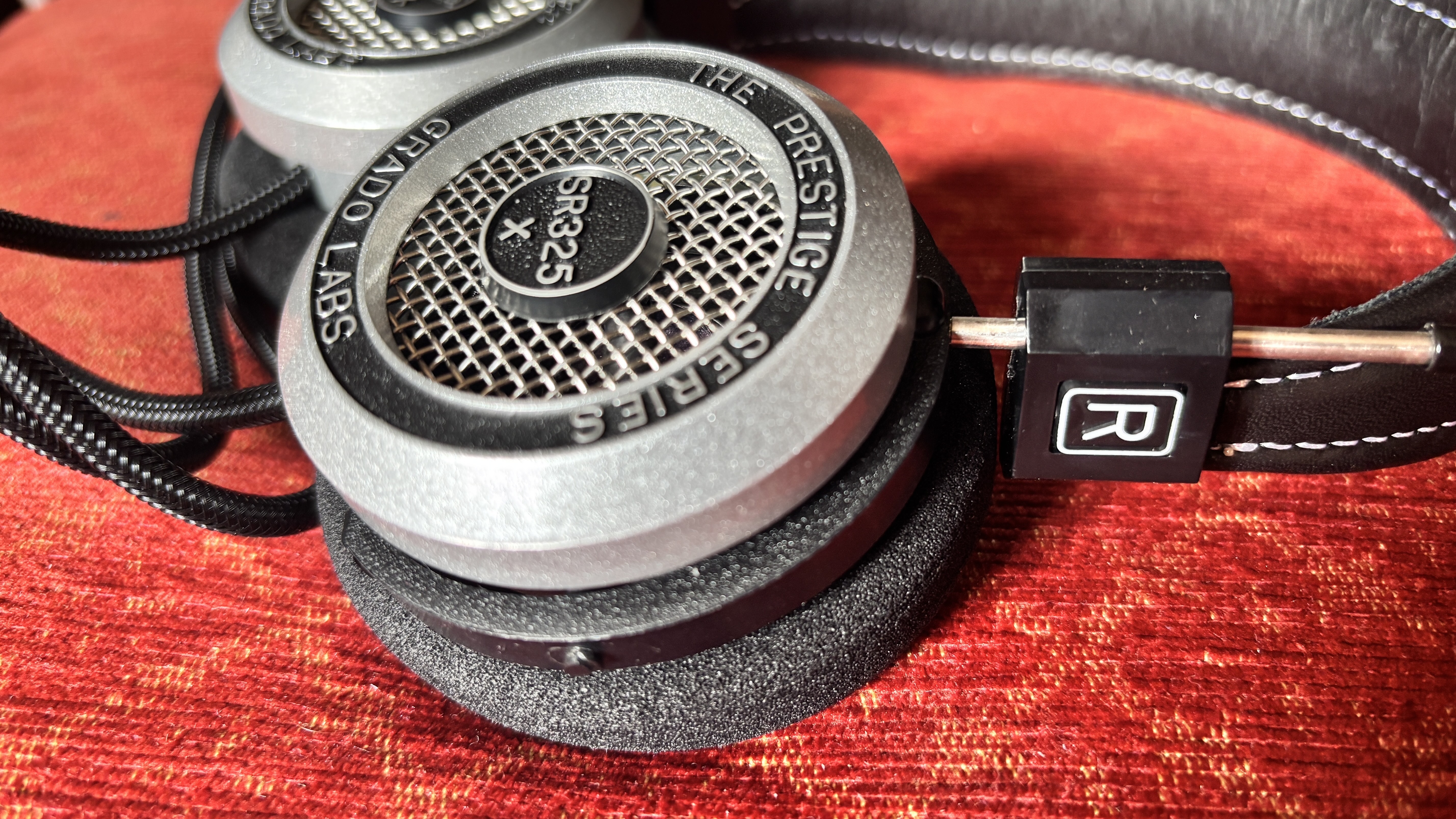 Grado SR325x wired on-ear headphones on a red fabric surface