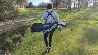 Photo of a man carrying a golf bag