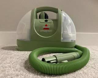 Bissell Little Green Portable Upholstery Cleaner (front shot with nozzle) on cream colored carpet