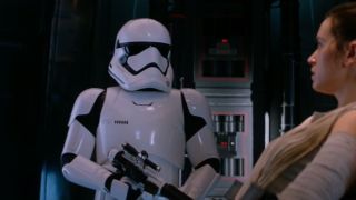 Daniel Craig wearing stormtrooper armor in front of Daisy Ridley in The Force Awakens