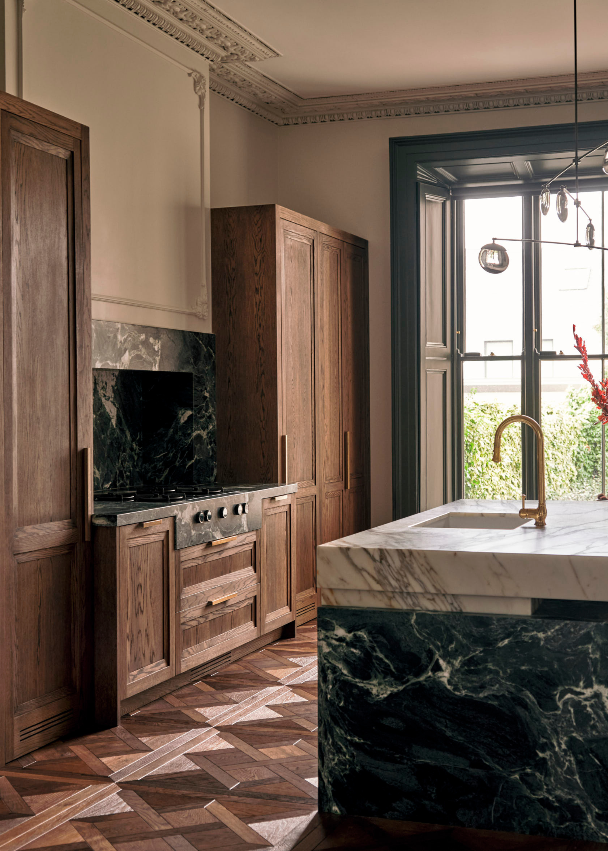 wooden floor kitchen with crown molding, wooden cabinetry and a marble hob and island
