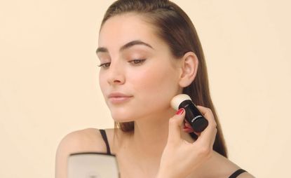 Model applying Chanel bronzer with brush 