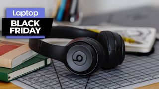 Beats solo 3 headphones on a desk next to book