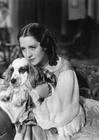 Norma Shearer hugs a dog