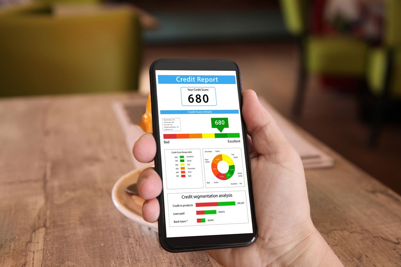 Image of someone holding their phone and checking their credit report and credit score.