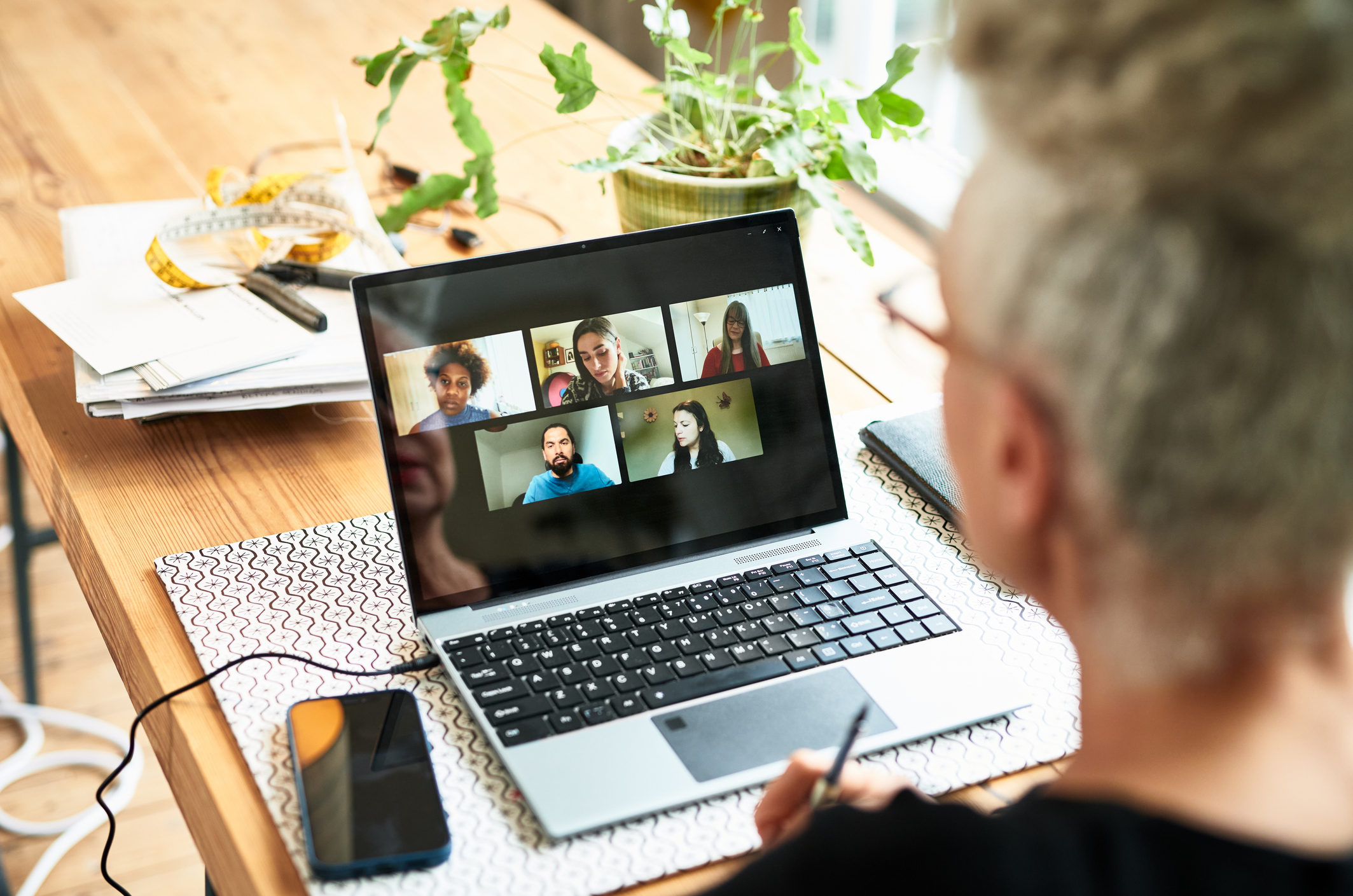 Business owner discussing ideas with colleagues on video call.