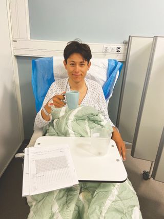 Torstein Træen sitting up in his hospital bed drinking from a mug