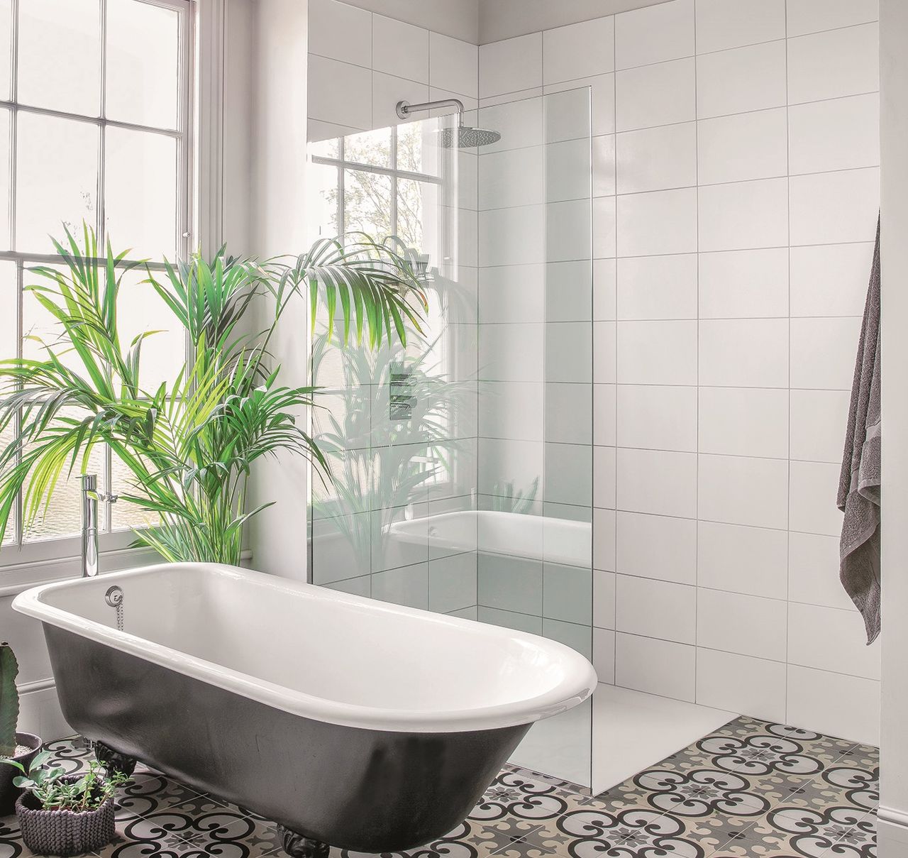 White tiled bathroom with freestanding bath and separate shower