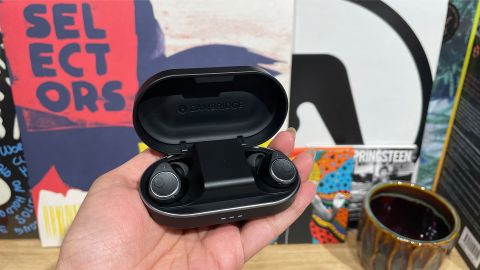 Cambridge Audio Melomania M100 wireless earbuds in case held in hand