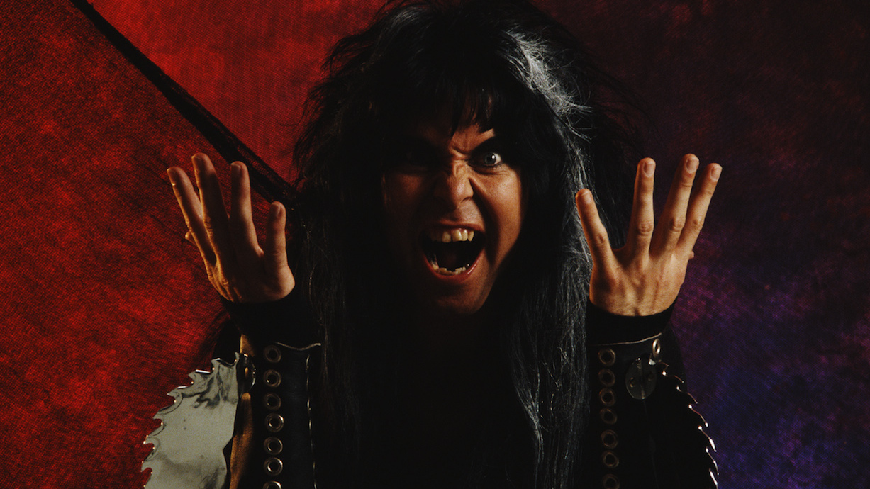 A close-up of Blackie Lawless with his hands raised, snarling