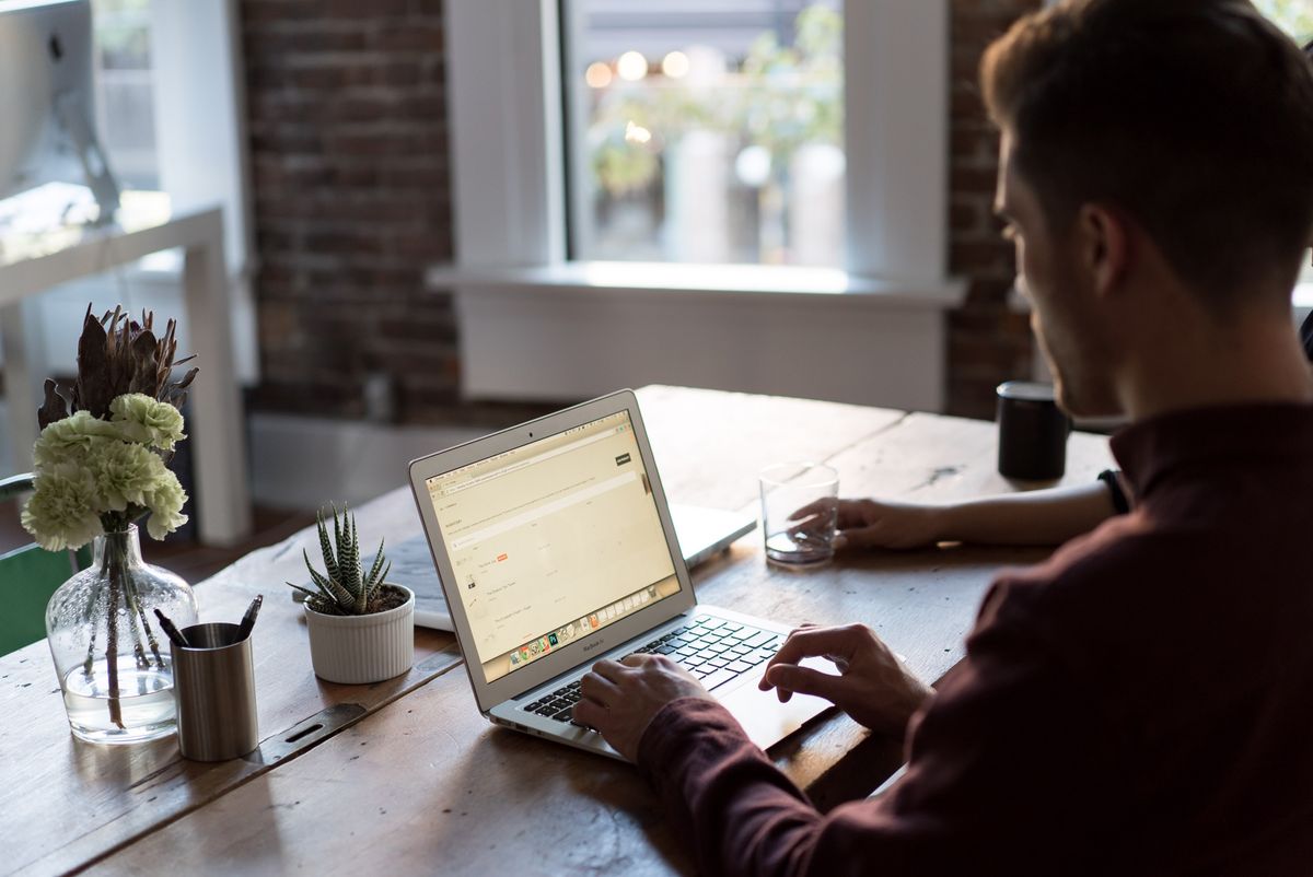 Man sitting at bench using laptop