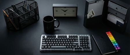 A selection of black-themed home office supplies on a black desk