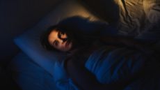 Woman lies in bed awake at night