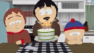 Randy holding up a birthday cake to the family who looks upset.