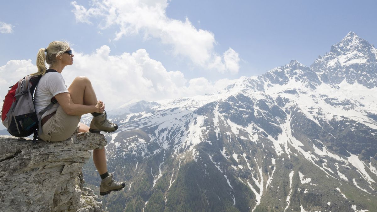 how to break in hiking boots: hiker on a rock outcrop