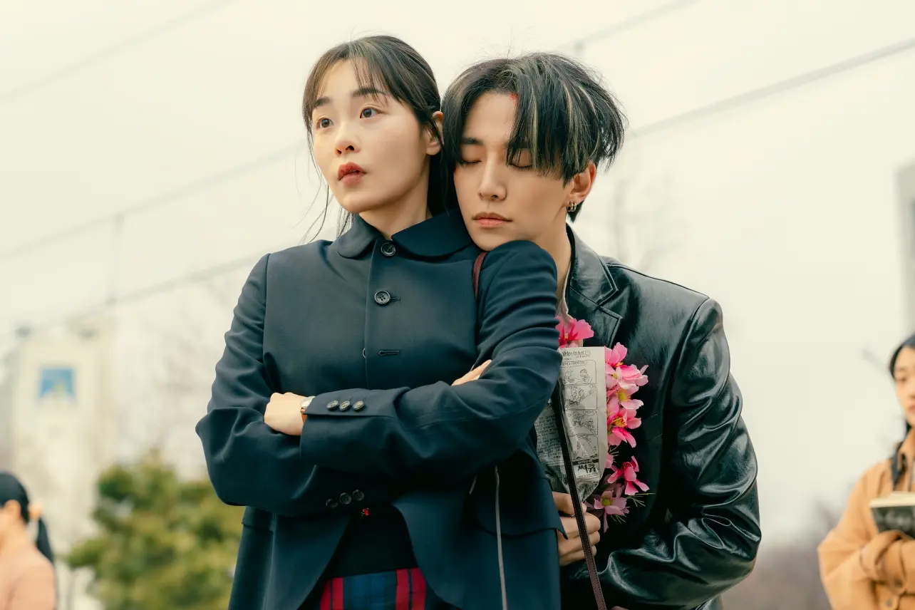 A man (Lee Jun-ho, right) holds flowers while resting his chin on a woman&#039;s (Ahn Eun-jin, left) shoulder, in the K-drama &#039;Typhoon Family.&#039;