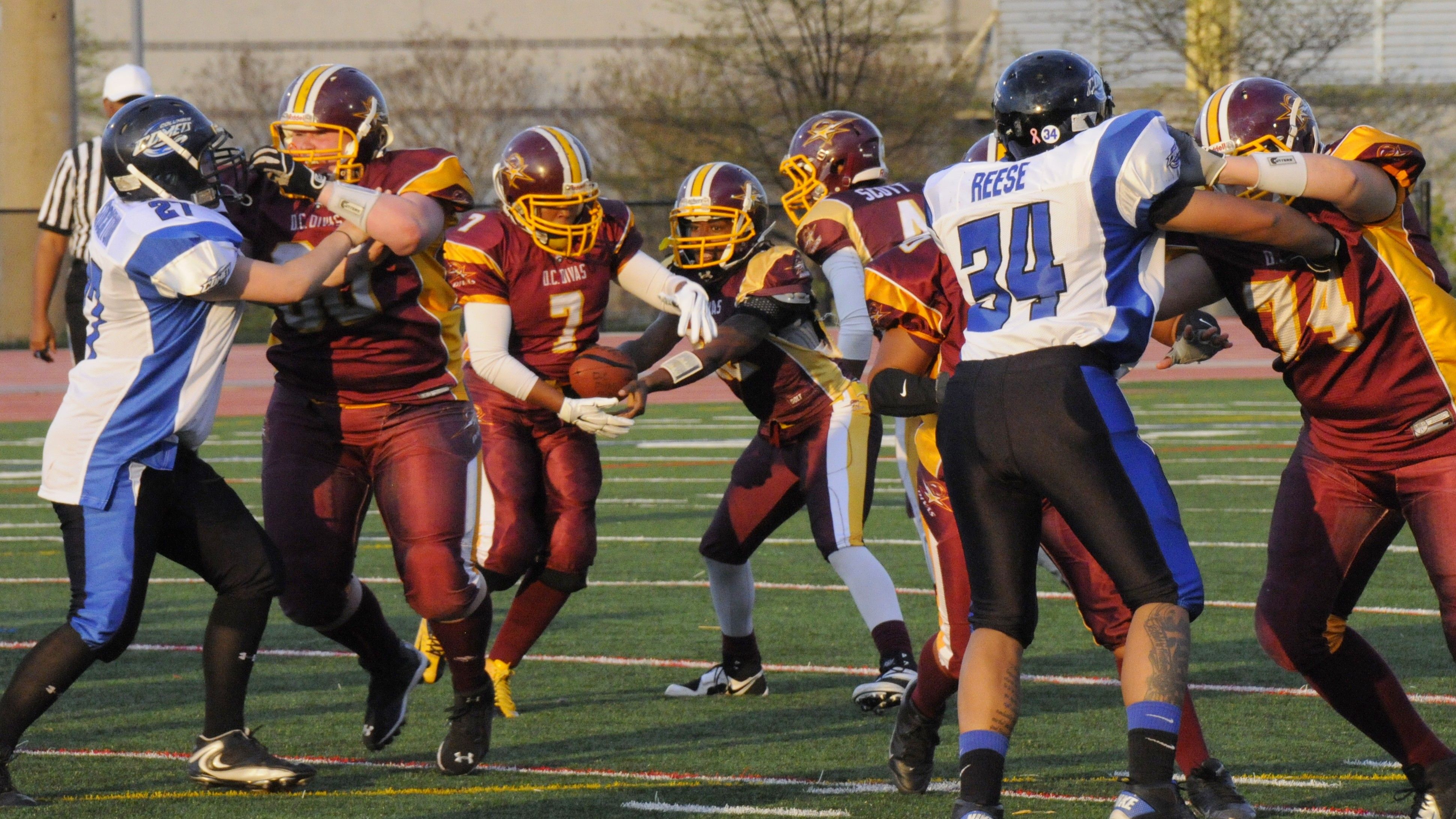 Clothing, Football helmet, Sports uniform, Sports gear, Grass, Football equipment, Sport venue, Helmet, Sports equipment, Trousers,